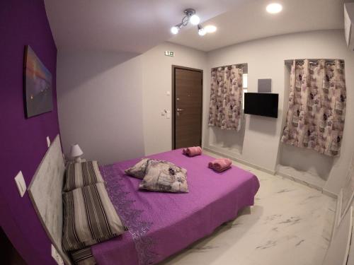 科孚镇MEMORIA的一间卧室配有紫色的床和紫色床单