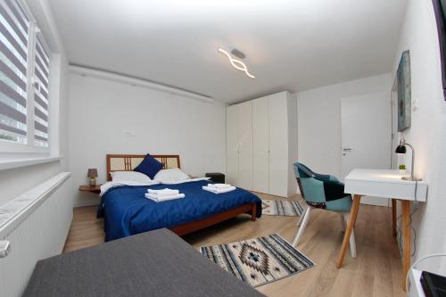 萨拉热窝Apartment Magnolia Old Town的一间卧室配有蓝色的床和一张书桌