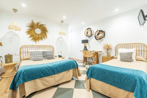 马拉加美洲酒店的一间卧室设有两张床,地面铺有一个 ⁇ 板。