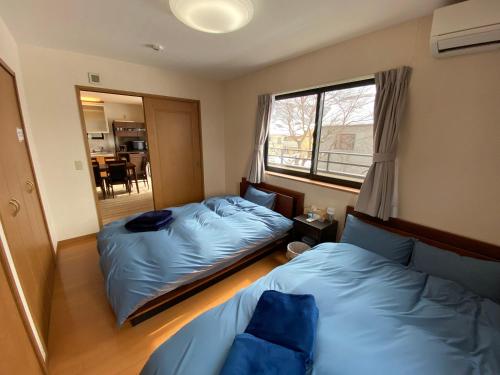 轻井泽Angel Resort Karuizawa的一间卧室设有两张床和窗户。