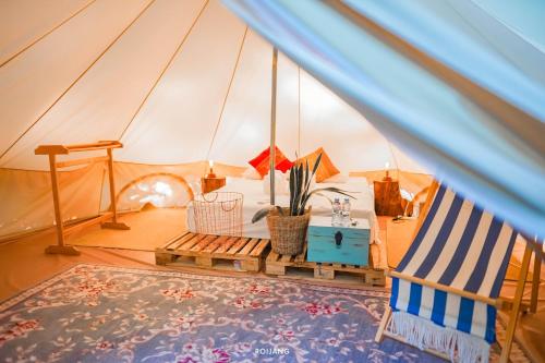 拉威海滩Roost Glamping - SHA Certified的带帐篷的客房,配有一张床和椅子