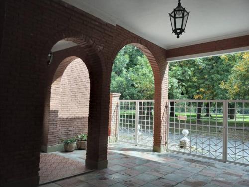 圣米格尔·德·图库玛Casa Frente Parque Guillermina的拱形庭院设有围栏和门
