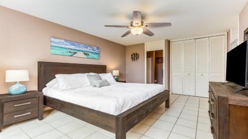 卡胡库Beach Cozy North Shore Turtle Bay Condo的一间卧室配有一张床和吊扇