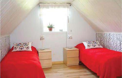 格内斯塔Lovely Home In Gnesta With Wifi的宿舍间的两张床,配有红色床单和窗户