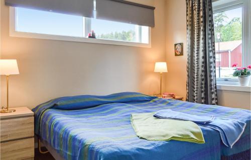 AspöAmazing Home In Strngns With 3 Bedrooms And Wifi的一间卧室配有一张蓝色的床和窗户