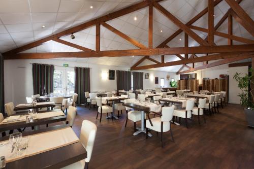 萨瑟纳日乐志思德萨司妮志酒店的用餐室设有桌椅和木制天花板