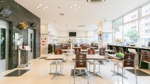 静冈Toyoko Inn Shizuoka eki Minami guchi的一间设有桌椅和窗户的自助餐厅