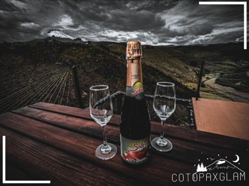 拉塔昆加Cotopaxglam的桌子上放有一瓶葡萄酒和两杯酒