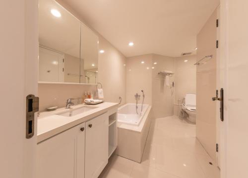 曼谷是隆中央酒店的白色的浴室设有水槽和卫生间。