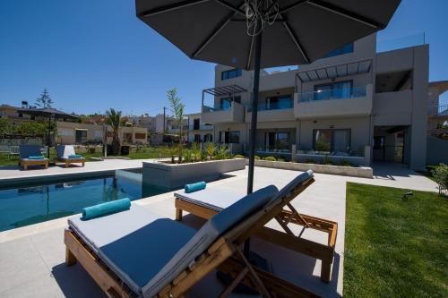 加拉塔斯Eleanthi Modern Living的一个带躺椅和遮阳伞的庭院,毗邻游泳池