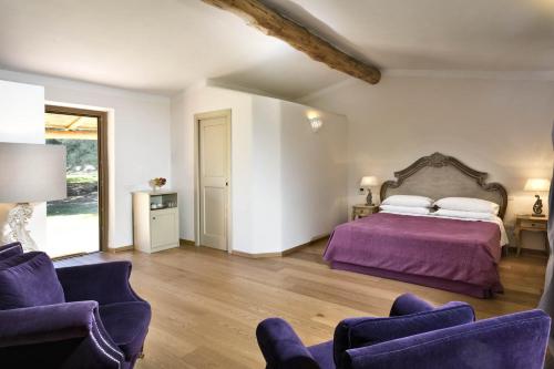 阿尔扎凯纳斯卡佐西亚卡鲁酒店的一间卧室配有一张紫色的床和两把椅子