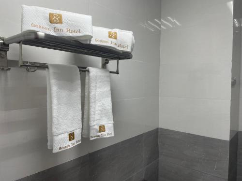 杜科姆Season Inn Hotel Apartment_Duqm的浴室设有挂在架子上的白色毛巾