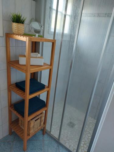 TrieblachKnusperhaus Ogris的一个带木制架子的淋浴间,配有4条蓝色毛巾