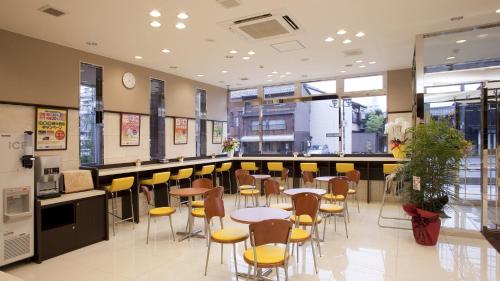 大津Toyoko Inn Kyoto Biwako Otsu的一间带桌椅的餐厅和一间酒吧