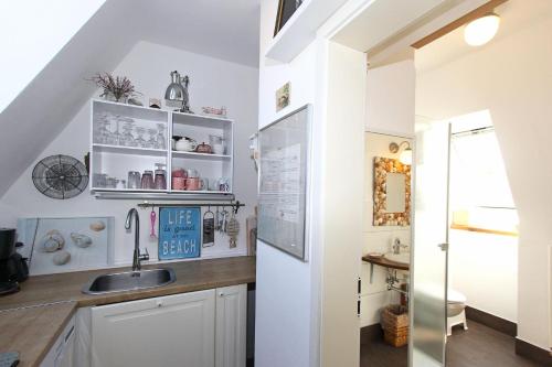 普雷罗Am Waldesrand的厨房配有白色橱柜和水槽