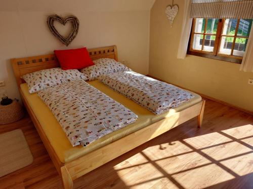 TrieblachKnusperhaus Ogris的卧室里的一张床铺,上面有红色枕头