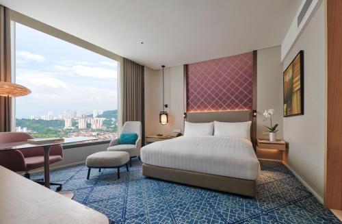 峇六拜槟城国际会展中心阿玛瑞酒店的配有一张床、一张桌子和一张桌子的酒店客房