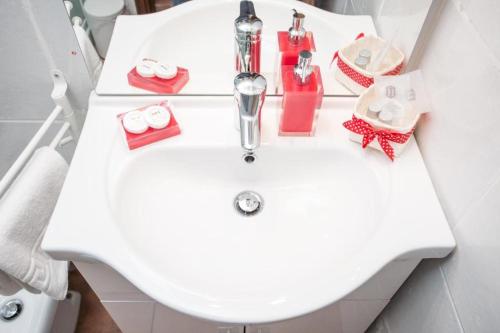 罗马Magenta Collection Moro 3的白色浴室水槽,上面有肥皂和化妆品
