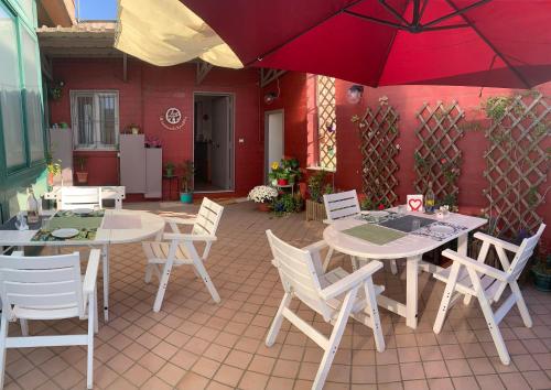 那不勒斯Starnone Bed&Book的庭院配有2张桌子和椅子以及遮阳伞。