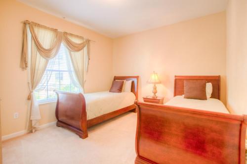 奥兰多Lovely Third-Floor Vista Cay Resort Condo的一间卧室设有两张床和窗户。