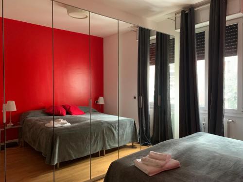 米兰Moscova Design Home的红色卧室设有两张床和镜子