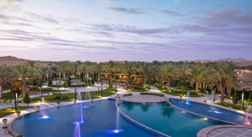 利雅德Dorat Najd Resort的棕榈树度假村的游泳池景