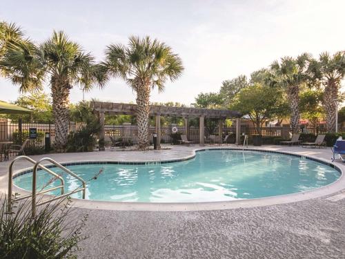 奥斯汀拉金塔套房酒店 - 奥斯汀机场的度假村内棕榈树游泳池