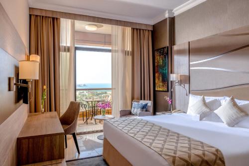 迪拜Two Seasons Hotel & Apartments的酒店客房设有一张大床和一个阳台。