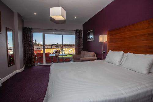 布莱克浦Blackpool Football Club Stadium Hotel, a member of Radisson Individuals的酒店客房设有一张大床和一个阳台。