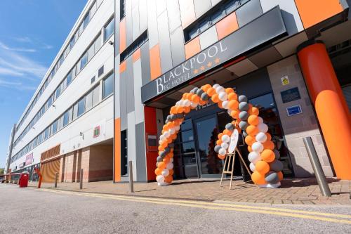 布莱克浦Blackpool Football Club Stadium Hotel, a member of Radisson Individuals的一座有橙色和白色气球拱的建筑