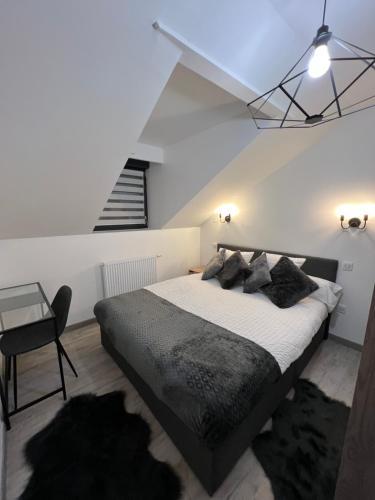 尚帕尼奥勒Appartement haut de gamme avec Jacuzzi Champagnole的一间带大床和楼梯的卧室