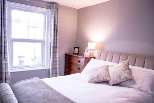 切尔滕纳姆Stunning 3 bed house in the heart of Cheltenham的卧室配有白色的床和窗户