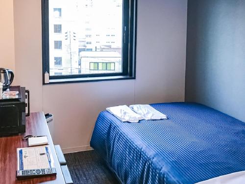 名古屋HOTEL LiVEMAX Nagoya Sakuradoriguchi的一间小卧室,配有床和窗户