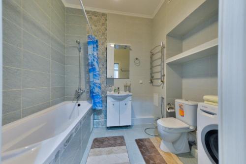 阿斯塔纳Однокомнатная элитная квартира в районе Экспо的带浴缸、卫生间和盥洗盆的浴室