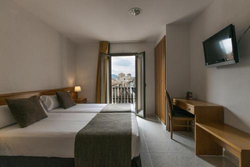 托尔特利亚阿尔塔格罗塔萨旅馆的酒店客房设有两张床和电视。