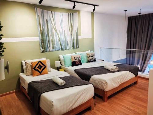 吉隆坡KL Duplex with balcony@Ekocheras MRT的一间卧室配有两张带枕头的床。