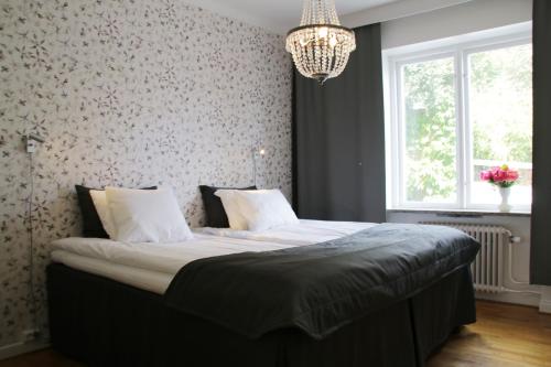 卡尔斯克鲁纳Hotell Conrad的一间卧室配有一张带吊灯的大床