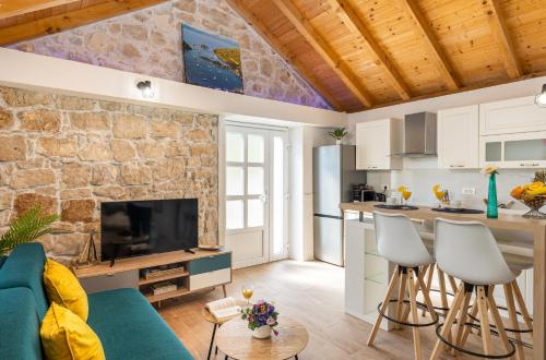 ProžuraPERLA - small comfy house with the terrace的厨房和带石墙的客厅