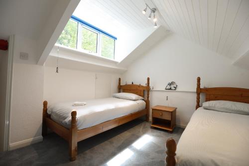 林茅斯Lyn View Cottage - Modern Lynmouth Townhouse的阁楼卧室设有两张床和窗户。