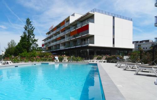 布吕热Appart-Hôtel Mer & Golf City Bordeaux - Bruges的大楼前设有游泳池的酒店