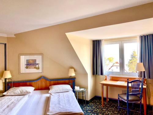 蒂门多弗施特兰德蒂门多弗施特兰德乡村酒店的配有一张床和一张书桌的酒店客房