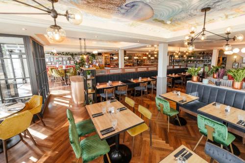 马伯斯Oyster House的一间带木桌椅的餐厅和一间酒吧