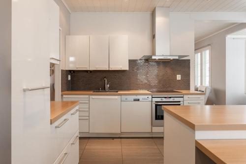 科科拉The Grey House的白色的厨房配有白色橱柜和水槽