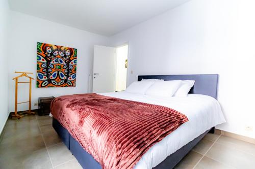 奥斯坦德Laluna holiday apartment的一间卧室配有一张带红色毯子的大床