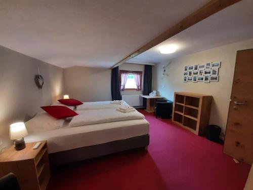 海特尔旺Pension Zeegershof的卧室配有带红色枕头的大型白色床