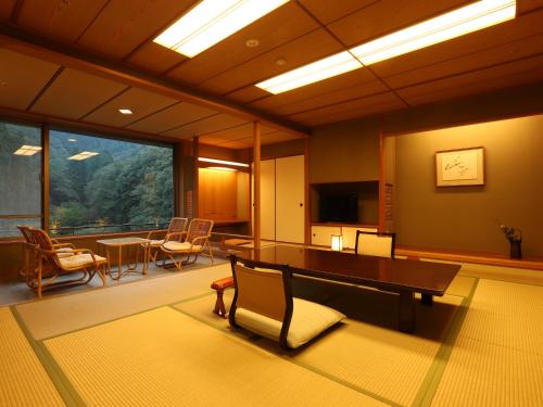丰冈市西村屋招月庭的一间带桌椅的房间和一间用餐室
