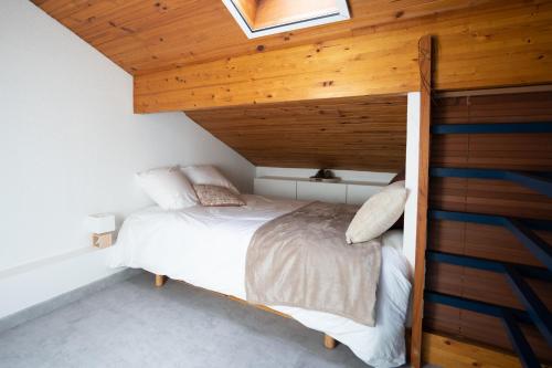 莫列马阿Chaleureux appartement à 500m de l’océan et 150m du Golf Moliets-Plage的木天花板的客房内的一张床位