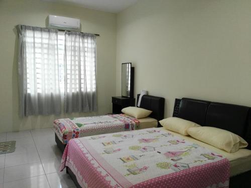 怡保Fong's Ipoh SImpang Pulai Homestay的客房设有两张床和窗户。