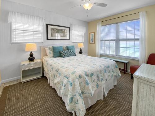圣罗莎海滩Highview Sunseekers 7 Condo的一间卧室设有一张床和两个窗户。