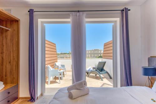 弗洛里亚纳Tritoni Valletta Boutique Hotel的一间卧室设有一张床和一个带庭院的滑动玻璃门。